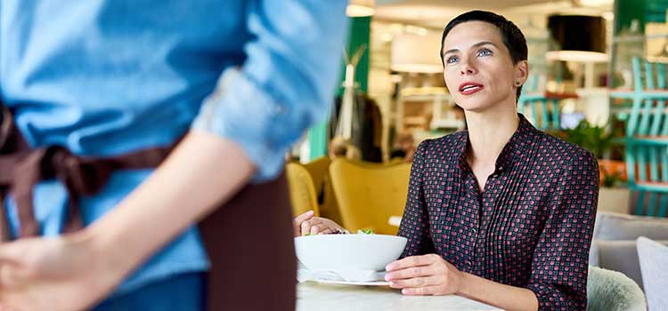 restaurant reviewer discusses her food with waitstaff member